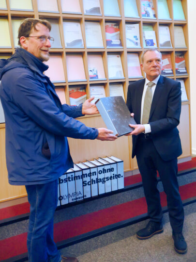 Vertrauenspersonen von NOlympia Hamburg übergeben dem Landeswahlleiter Aktenordner mit Unterschriften.